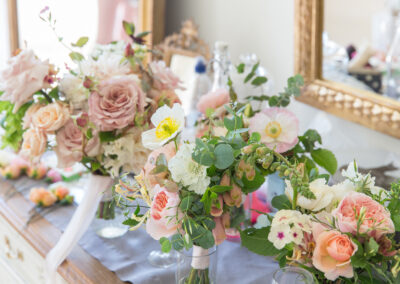 Bouquets of pink and white flowers and roses among green foliage tied in ribbon
