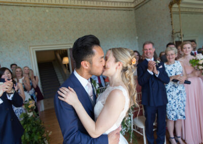 bride and groom kissing at the alter during wedding ceremony in the drawing room