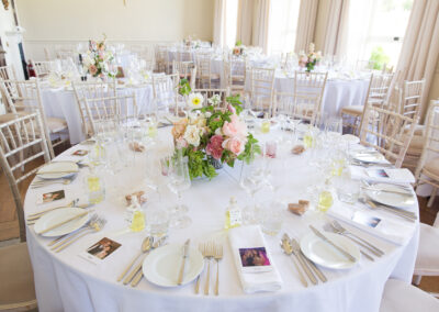 Italian inspired wedding reception with white clothed tables and pink floral bouquets
