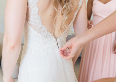Bride has her dress done up on the morning of her wedding