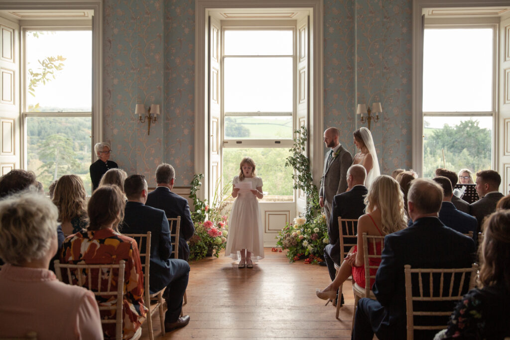 Child doing a reading during the wedding ceremony, in the drawing room.