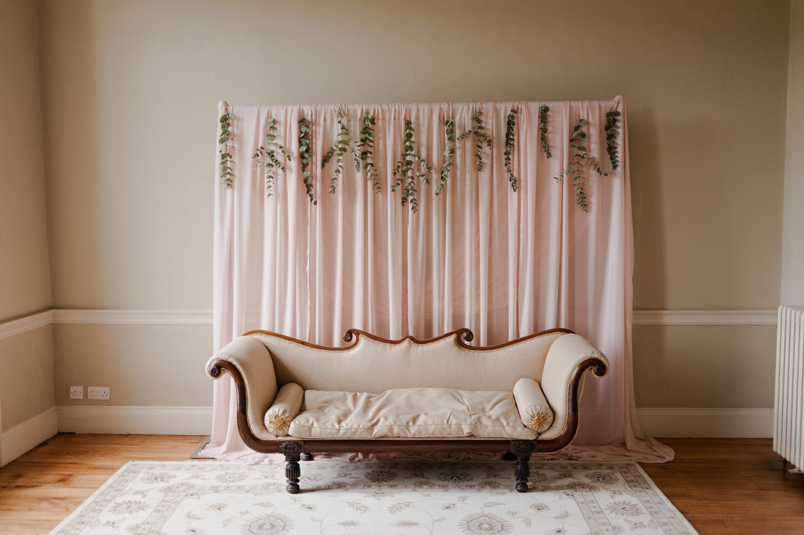 Couch under pink photo backdrop.