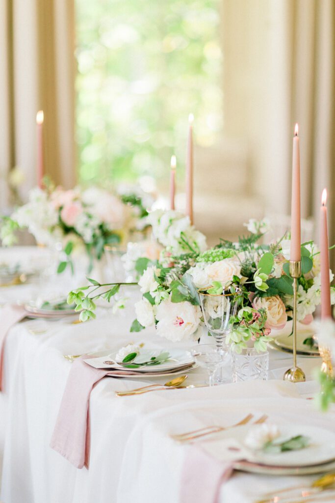 Table for wedding reception with bouquets, in ballroom.