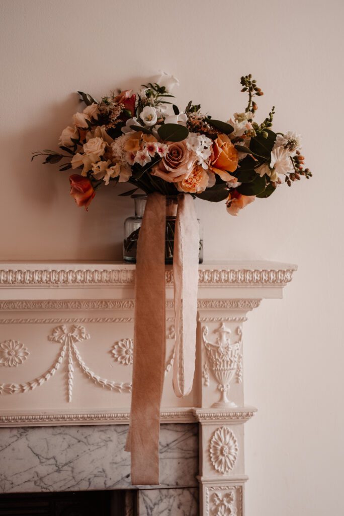 Bouquet of sustainable wedding flowers, on mantlepiece.
