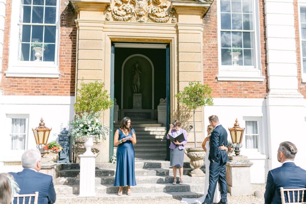 Wedding guest doing wedding ceremony reading at stately home in England.