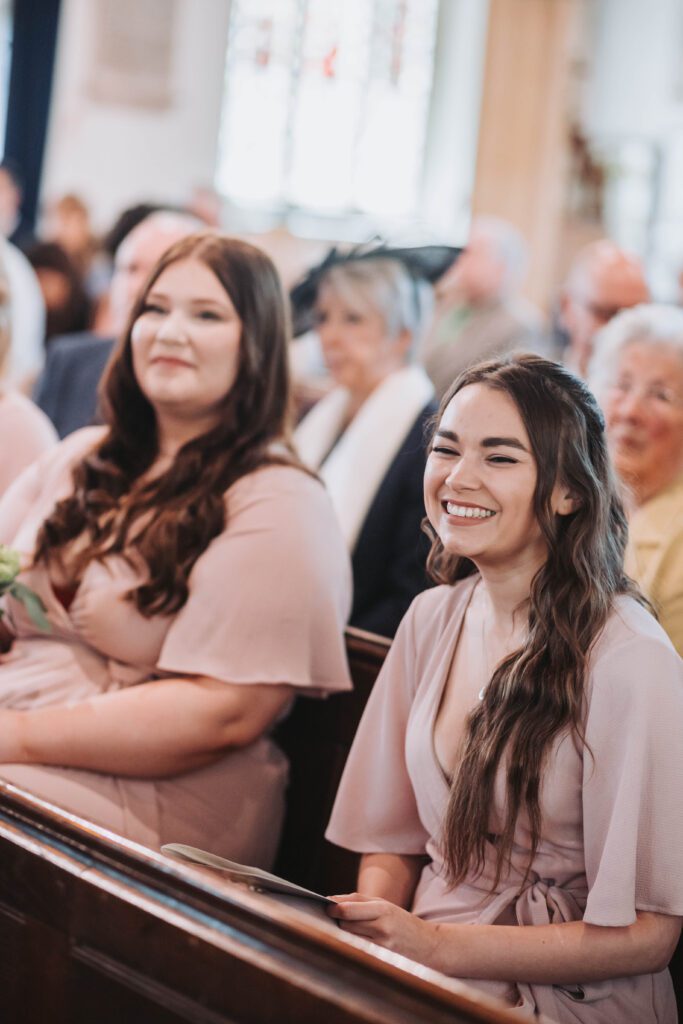 Guests laughing during wedding ceremony reading in England.