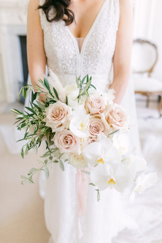 Bride holding floral bouquet, for black tie wedding.