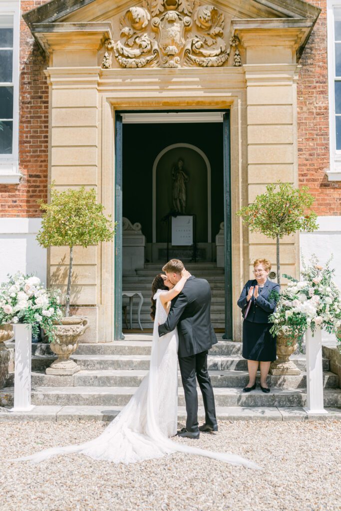 First kiss, during outdoor wedding ceremony in front of Pynes House.