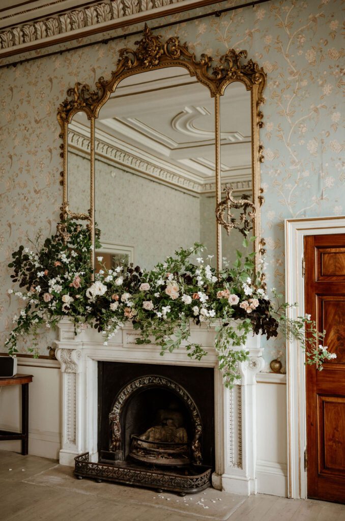 Large mantlepiece floral arrangement for bespoke wedding at Exeter wedding venue, created by Devon wedding florist.
