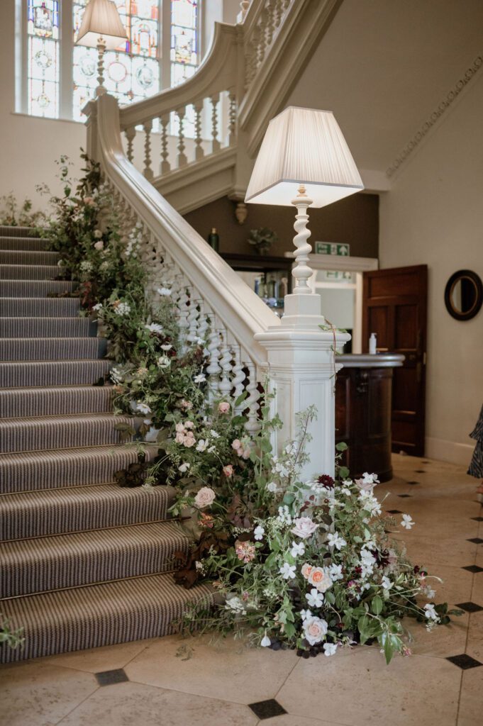 Wedding flowers up staircase, created by wedding florist based in Devon.
