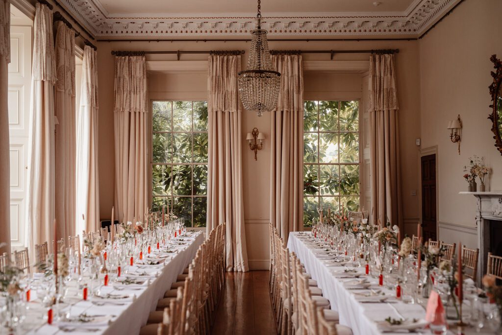 A wedding breakfast setup in a ballroom, decorated with seasonal flowers by The Good Florist.