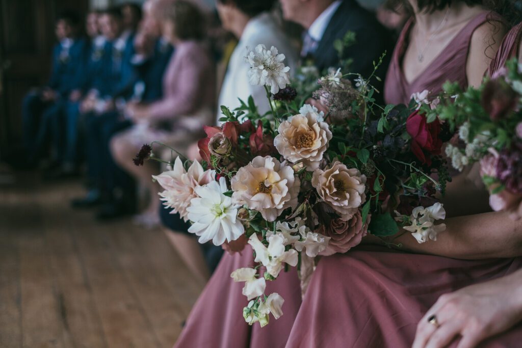 A bouquet of seasonal blush, copper and cream wedding flowers.