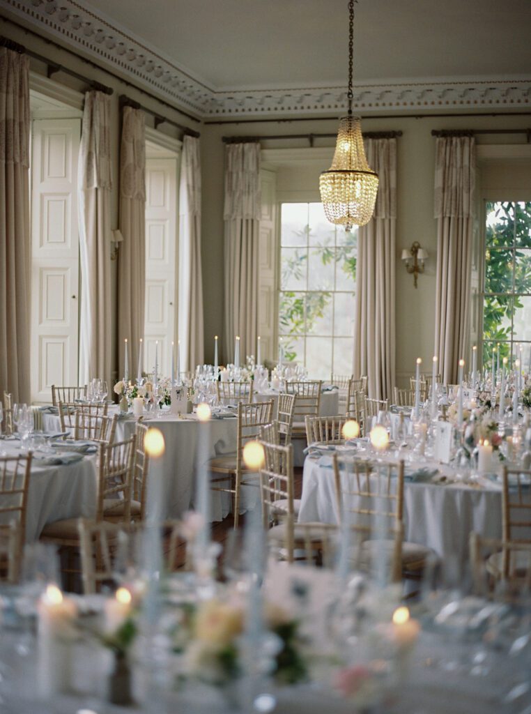 A luxury wedding reception of candles and pale blue linens, for an elegant English country house wedding.