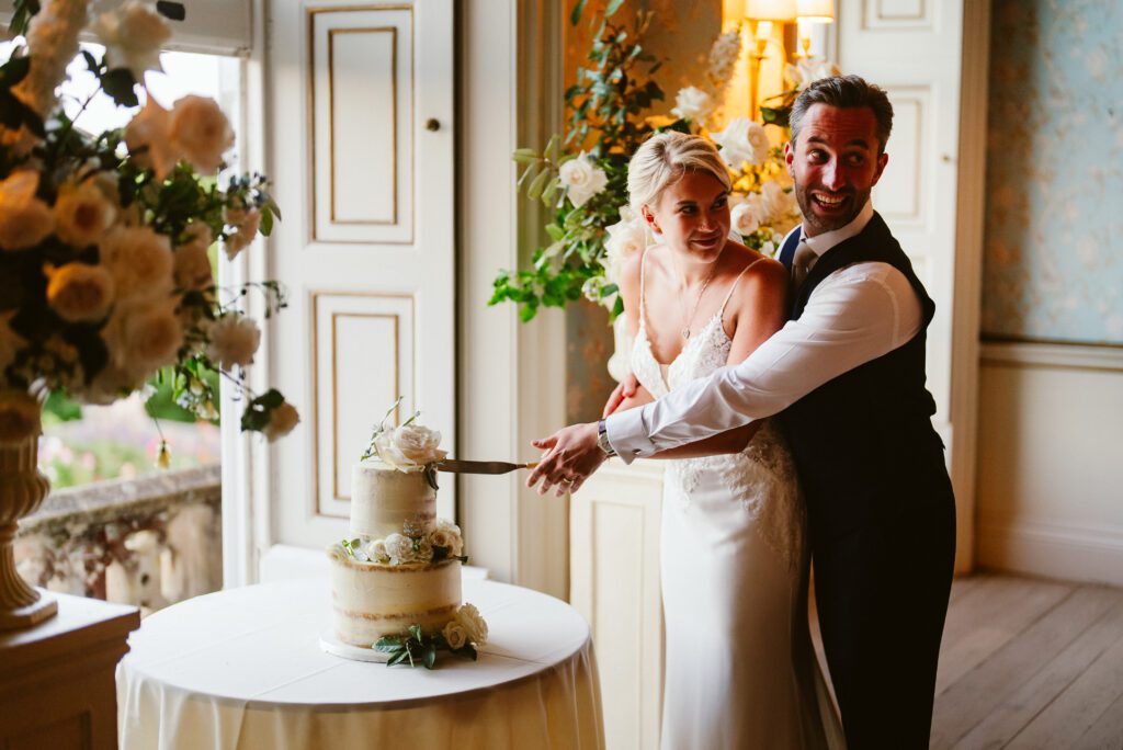A bride and groom cut the cake during a Pynes House wedding.