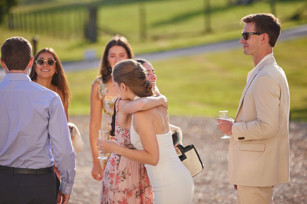 Guests embrace, during a rehearsal dinner before a wedding.