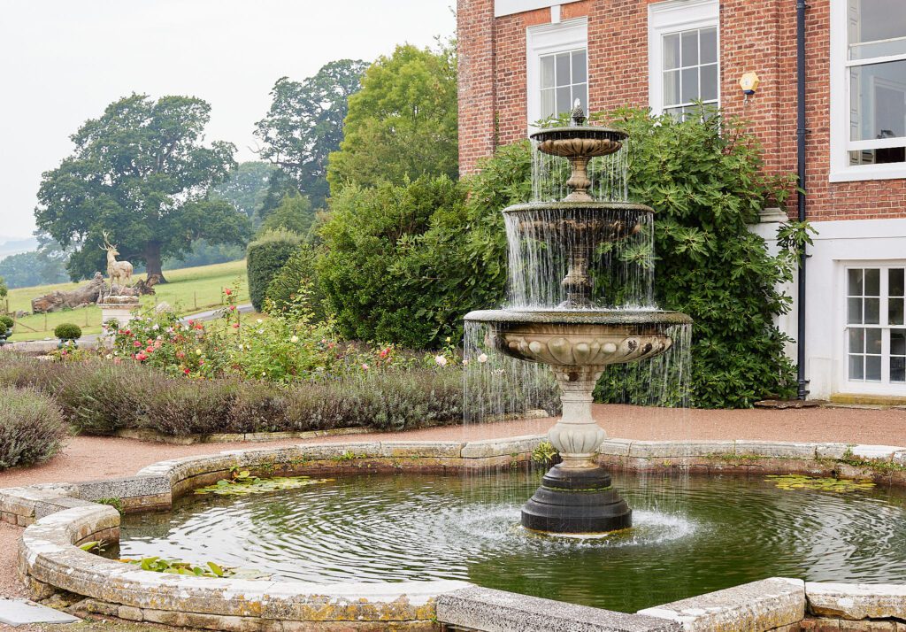A historic fountain in the parterres at an English wedding venue.
