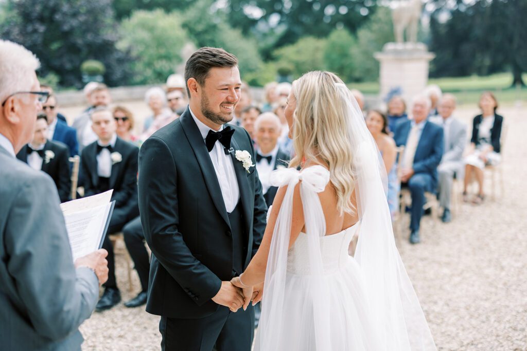 A bride and groom say their vows, at an outdoor wedding venue