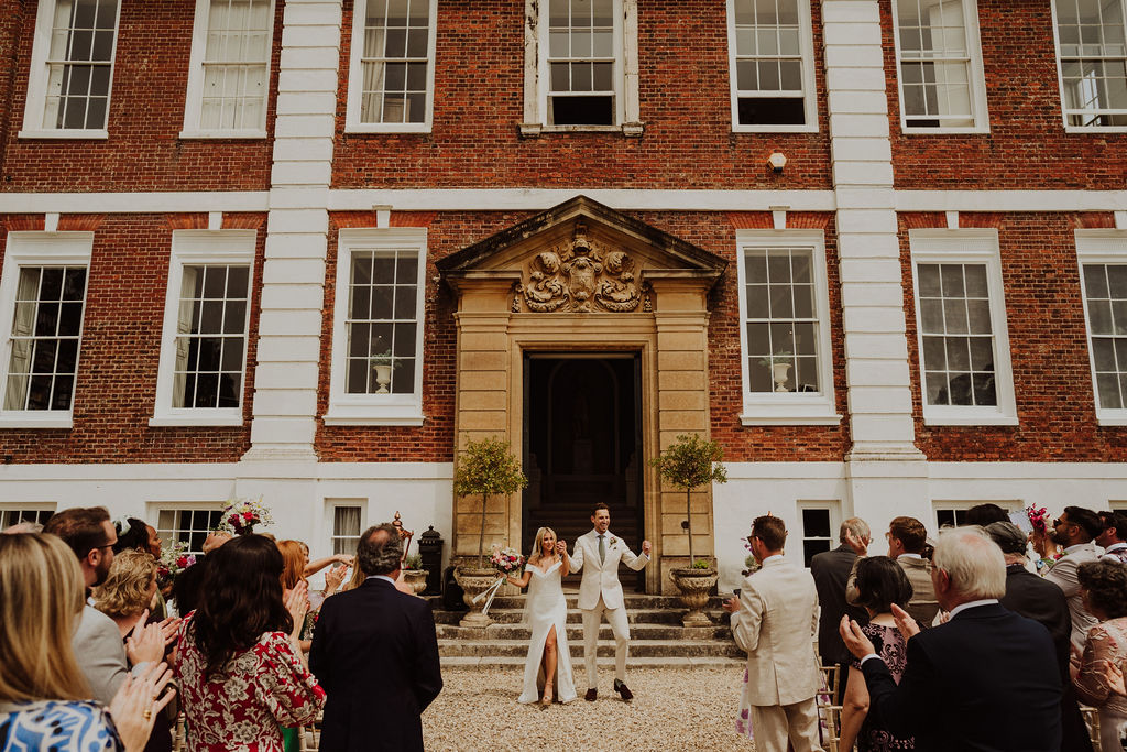 A bride and groom enjoy a confetti shot at their English outdoor wedding venue