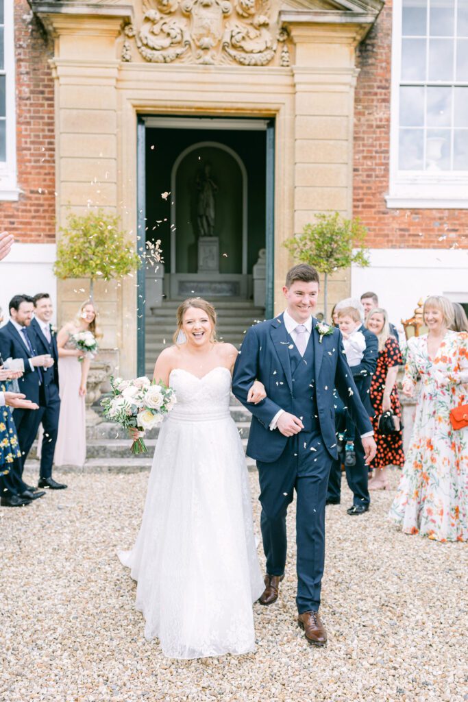 A bride and groom smile during their confetti shot, during a UK wedding