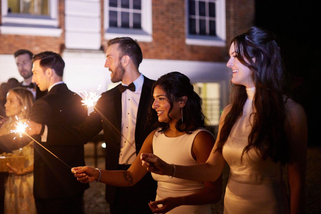 Wedding guests enjoy evening sparklers