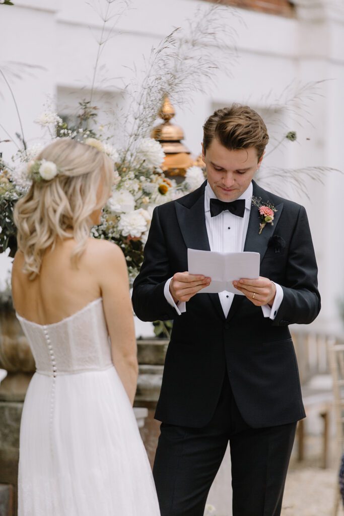 Groom reading personal vows to bride at Pynes House