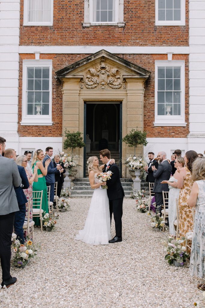 Bride and groom getting married outside Pynes House on the courtyard